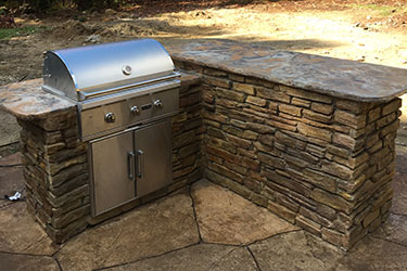 backyard grill with stone countertops on island
